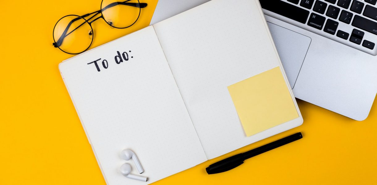 Home office desk workspace with laptop on yellow background